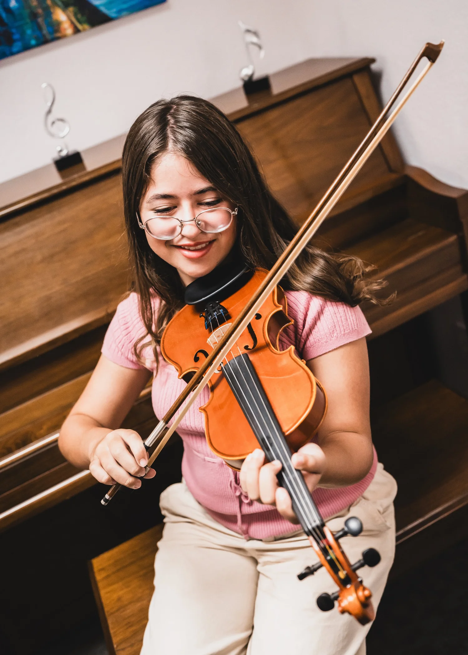 A smiling Heart Beats violin student making music in her lesson