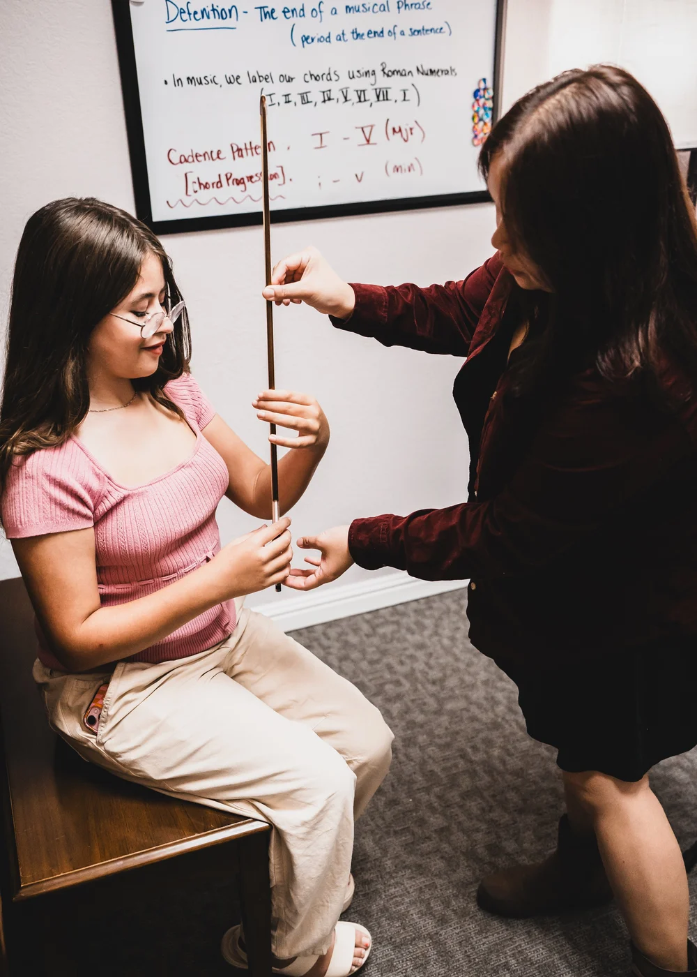 A Heart Beats violin teacher helping a student develop her bow hold