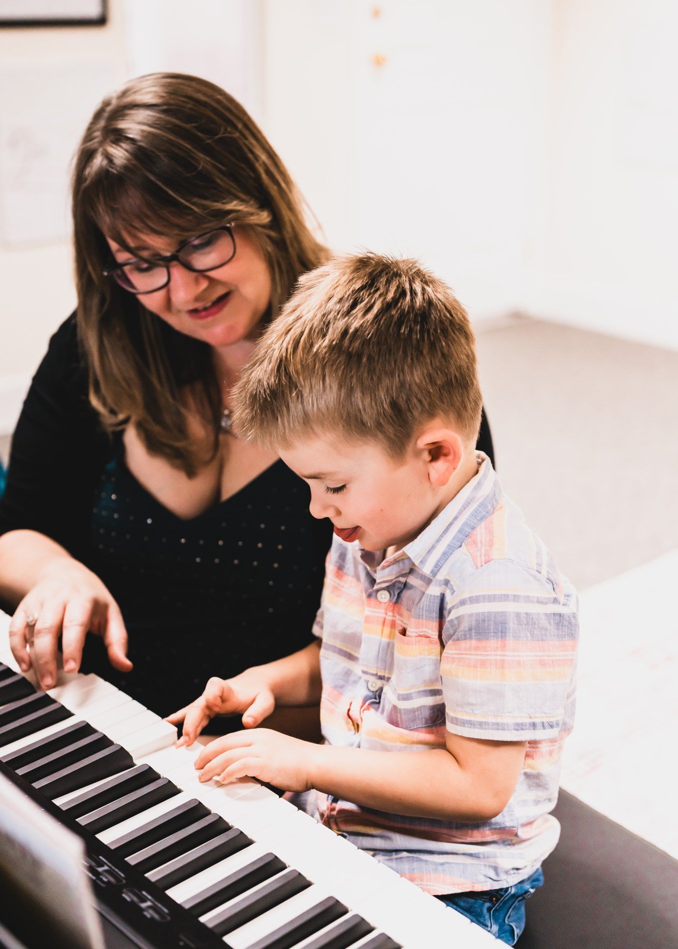 A mother and child sharing a musical discovery at a keyboard