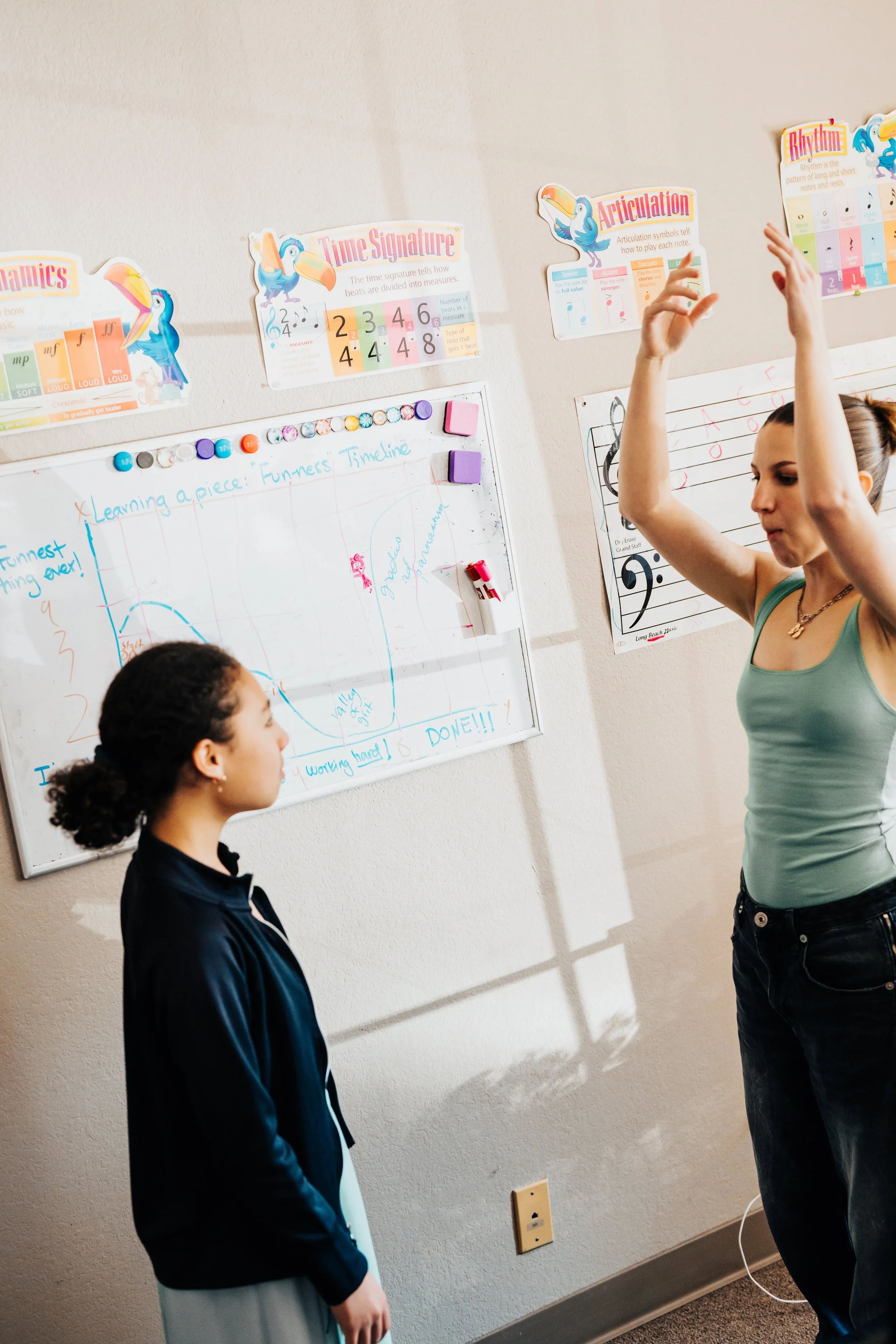 Moriah demonstrating a vocal exercise as her student watches and learns