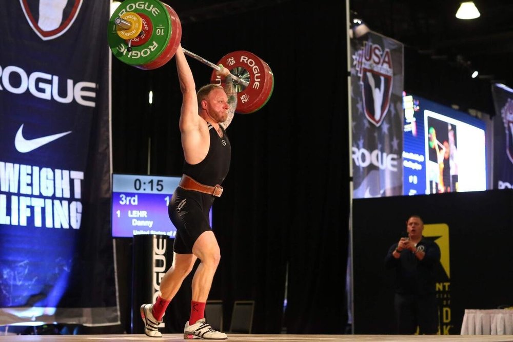 Danny Lehr locking out a jerk on the platform at a USA Weightlifting national event