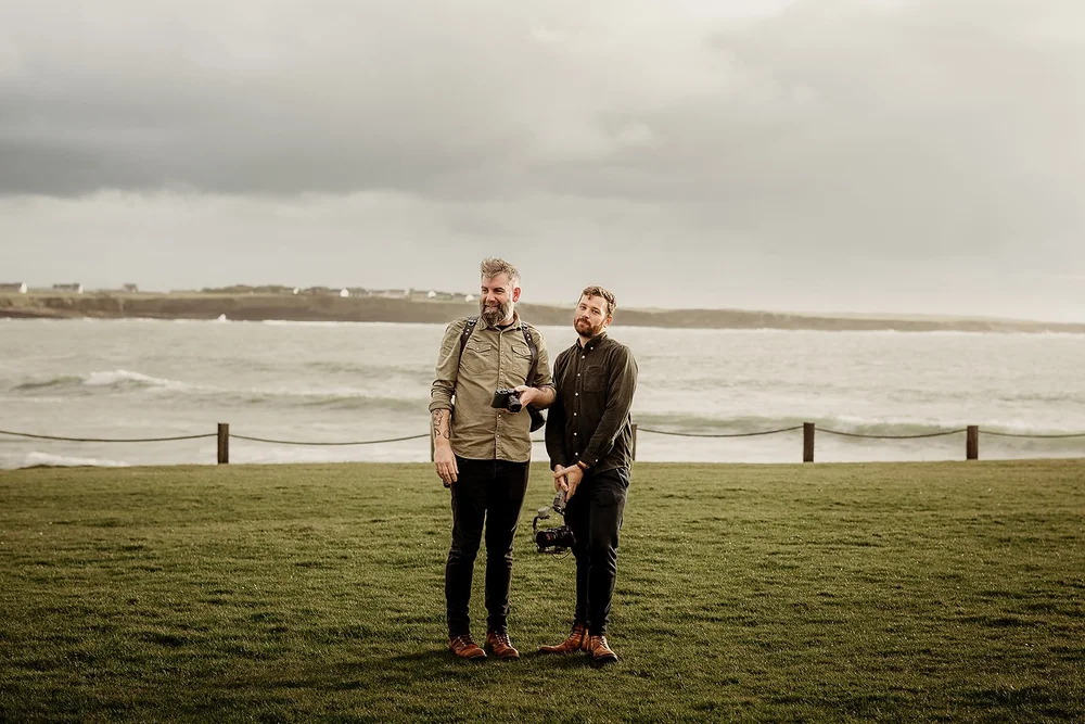 Two members of the Bokeh team with cameras beside the sea
