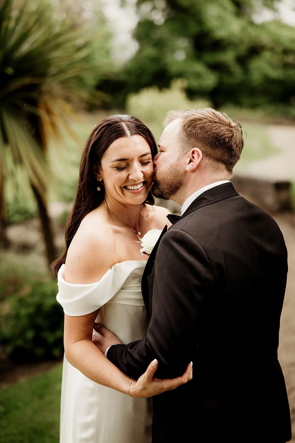 Ciara smiling as Jack kisses her cheek on their wedding day