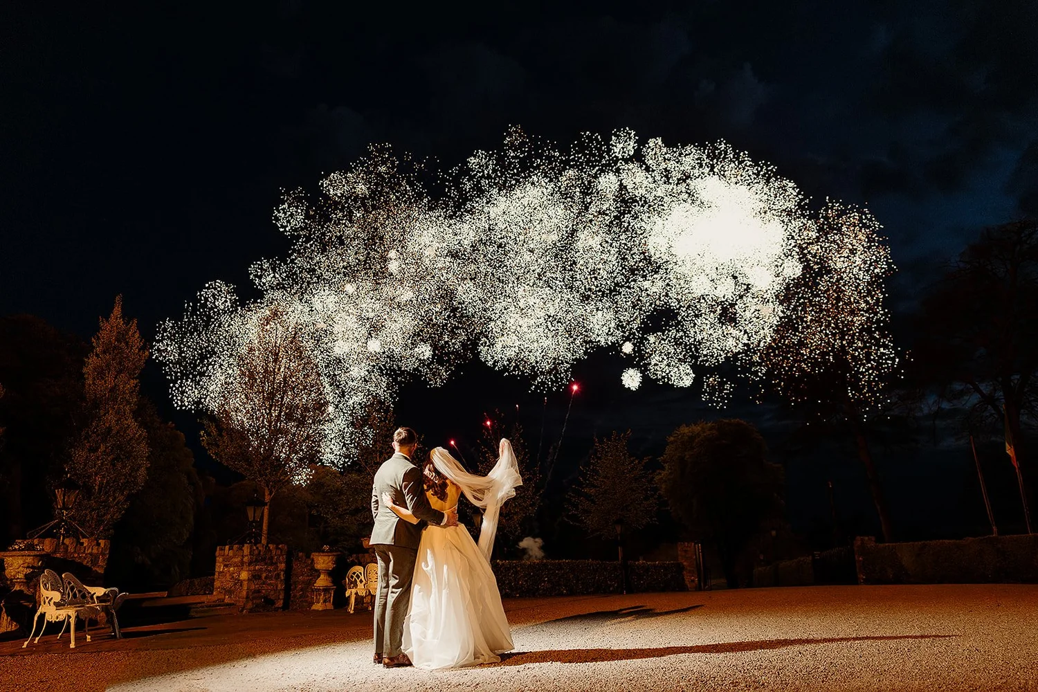 Abbie and Patrick on the castle lawn as fireworks light up the night sky