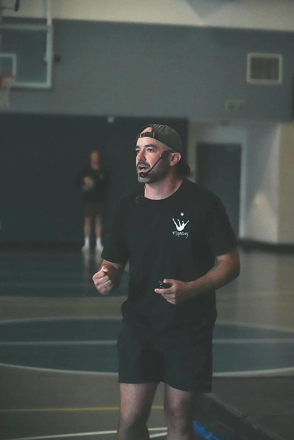Pat Graves speaking with a headset microphone during a live school assembly