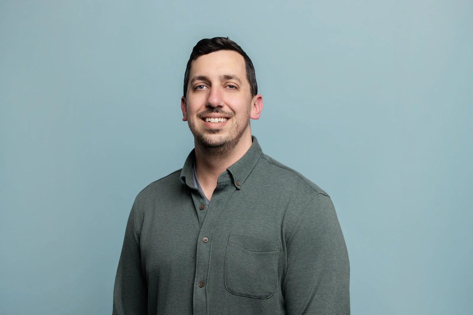 Fluor summit headshot of a man in a green shirt against a blue background