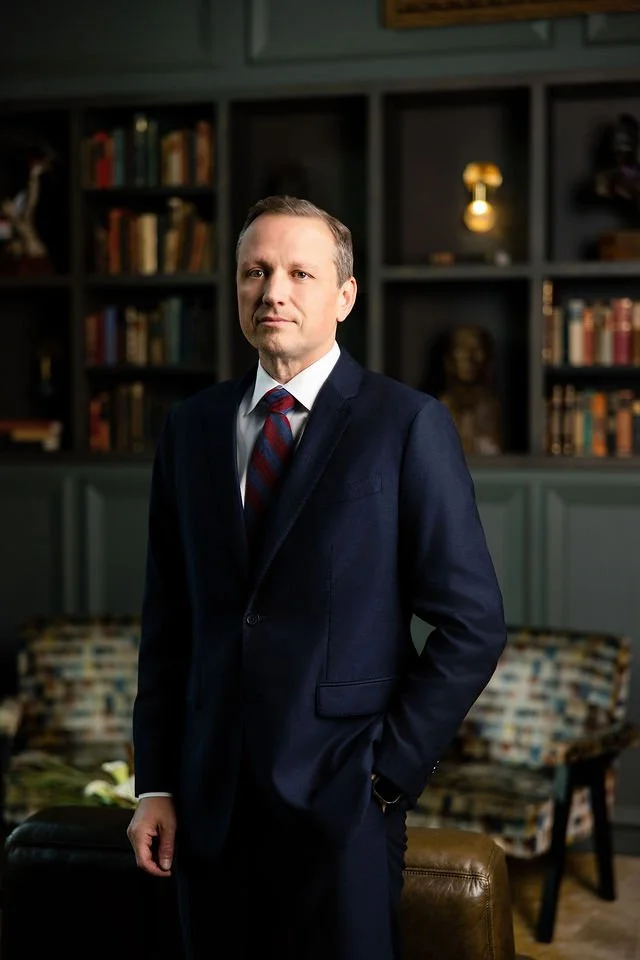Clardy Law Firm team member standing in a dark suit and striped tie in the Bohemian library