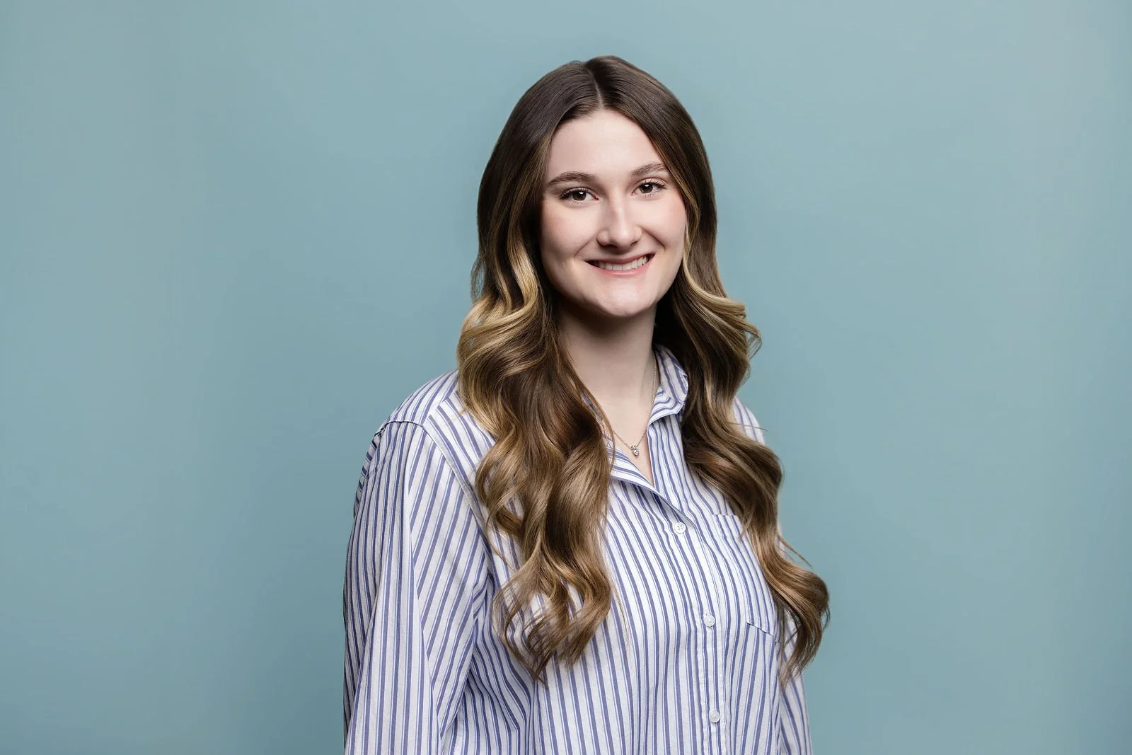 Fluor summit portrait of a woman in a striped shirt against a blue background