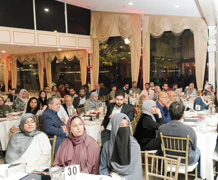 Guests seated at round tables in the marina ballroom, listening to the evening's program