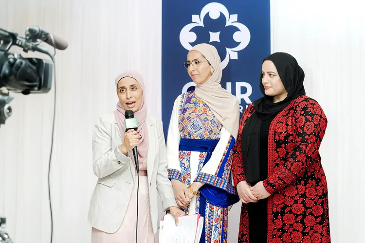 Three CAIR-NY staff members giving an on-camera interview in front of the CAIR-NY backdrop