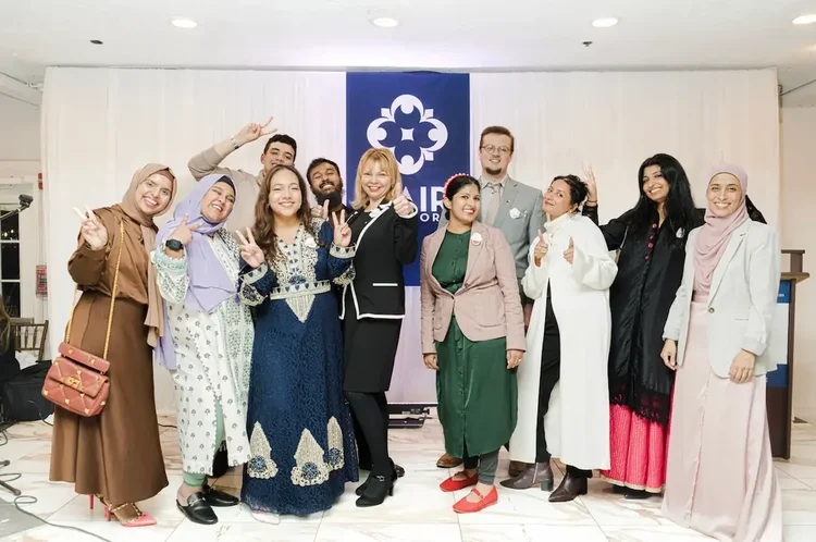 Eleven CAIR-NY staff and volunteers posing together on stage in front of the CAIR-NY banner