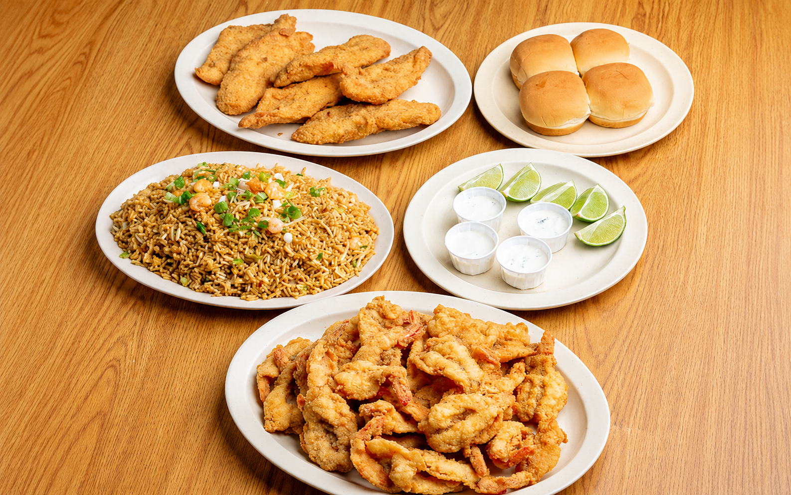 Connie's seafood party pack with fried seafood, shrimp fried rice, rolls, limes, and sauces