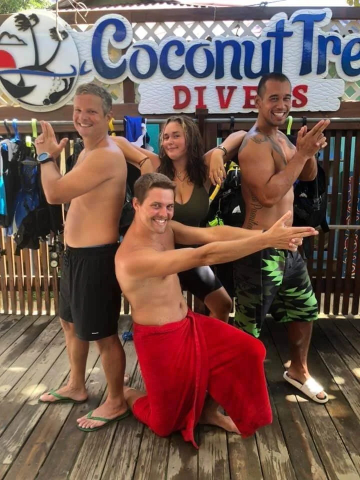 PADI Divemaster trainees doing a Charlie's Angels pose, Roatan