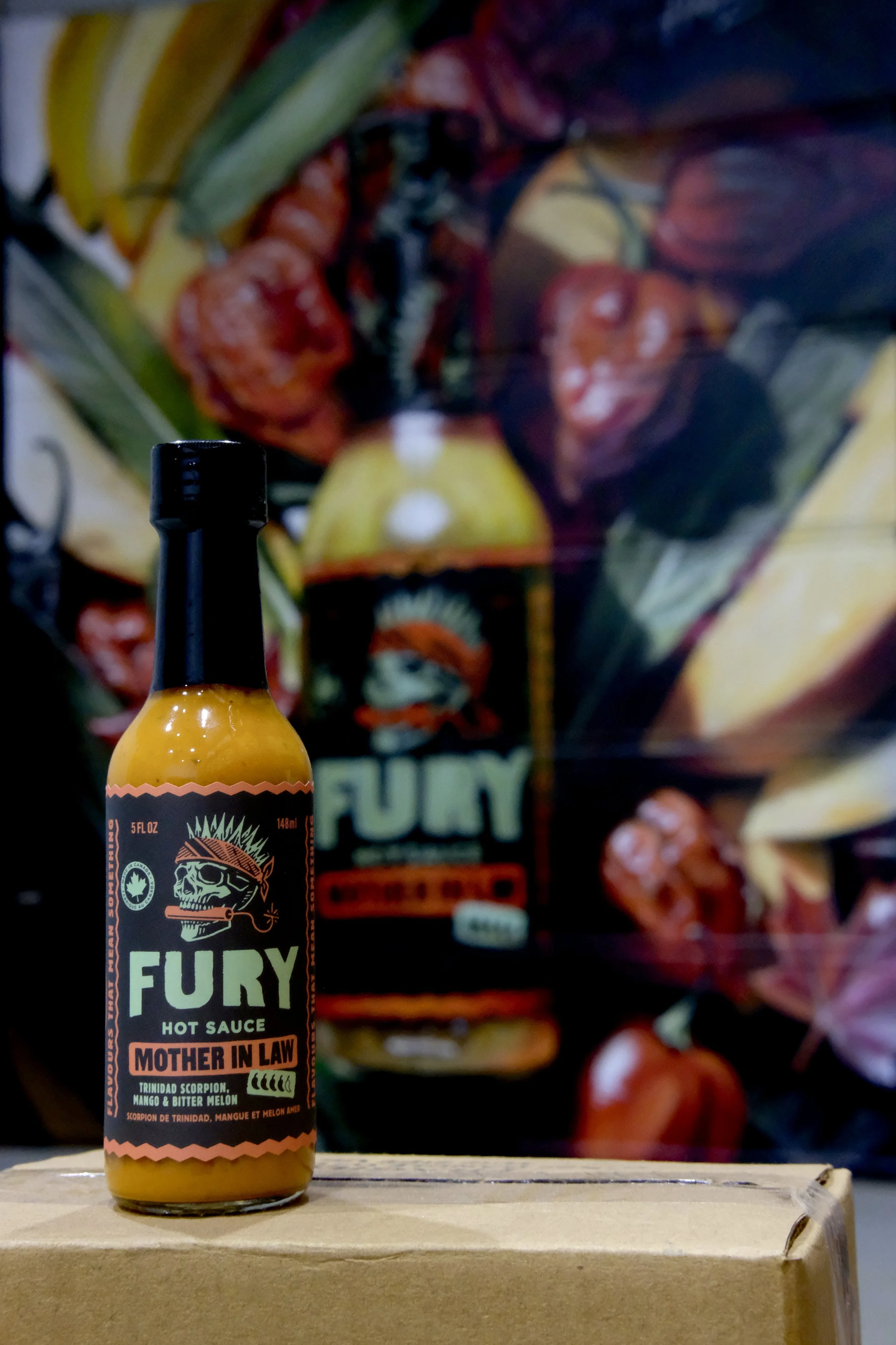 FURY Mother in Law hot sauce bottle in front of the matching mural