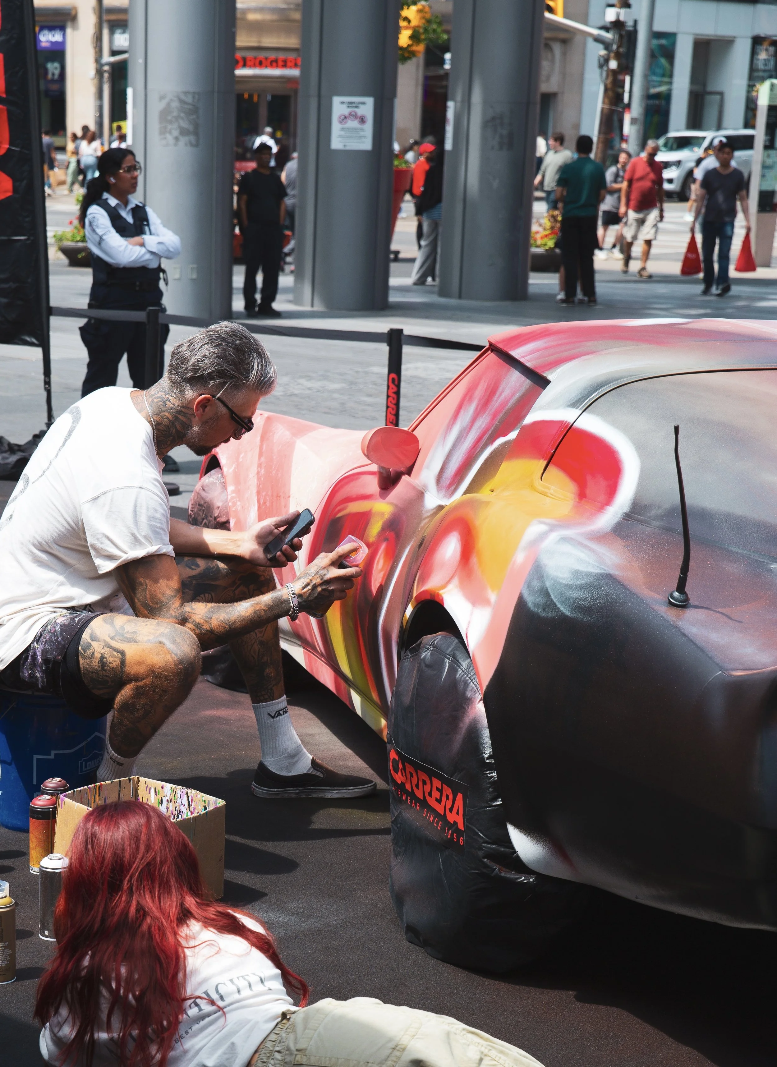 TheHalfDecent painting colourful artwork on a car at a Carrera live event