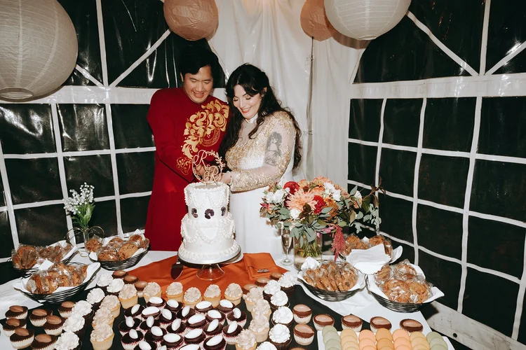 Two people cut their wedding cake.