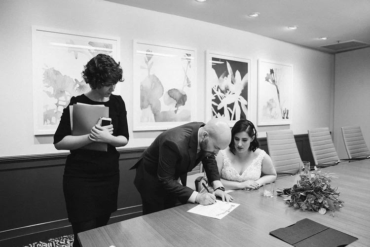 A couple signs their marriage license.