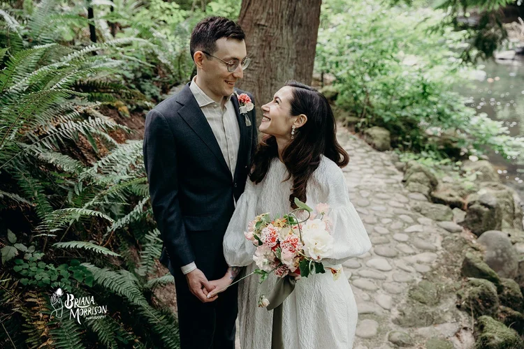 A groom and a bride smile at each other on their wedding day.