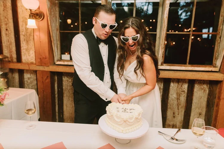 A bride and groom cut the cake on their wedding day.