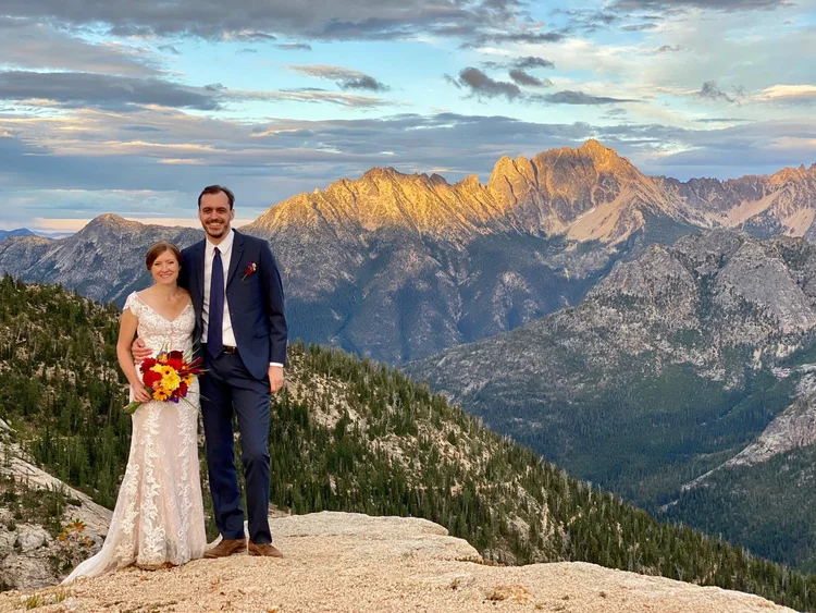 A couple stands on a mountaintop for their wedding.