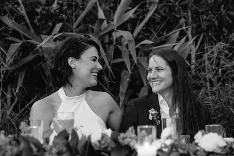 Two brides look at each other on their wedding day