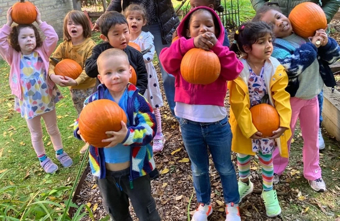 Happy children playing with pumpkins together at our childcare center