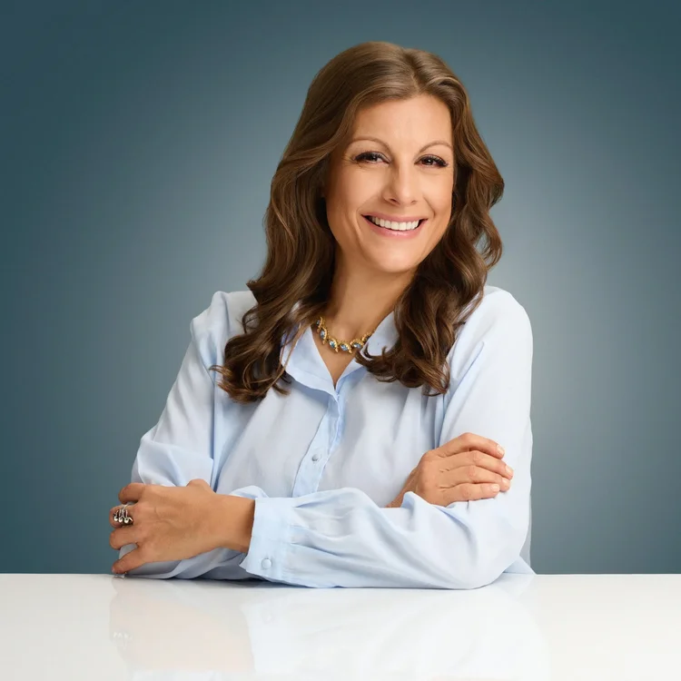 Studio portrait of a woman in a white blazer.