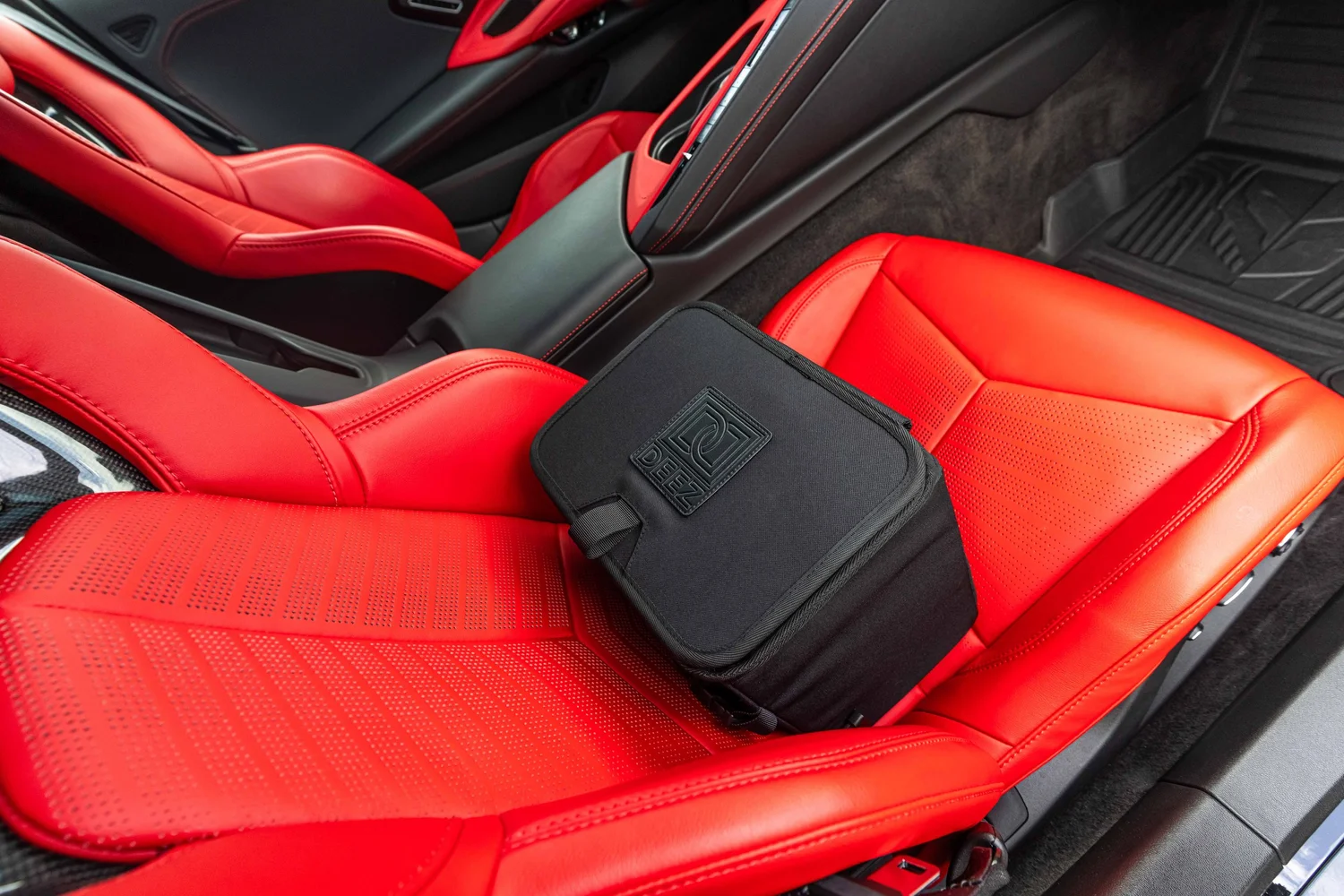 Double Deez Goodz car trash can photographed on vivid red leather vehicle seats, lifestyle product photography by Ian Jones of ISJDESIGNS.
