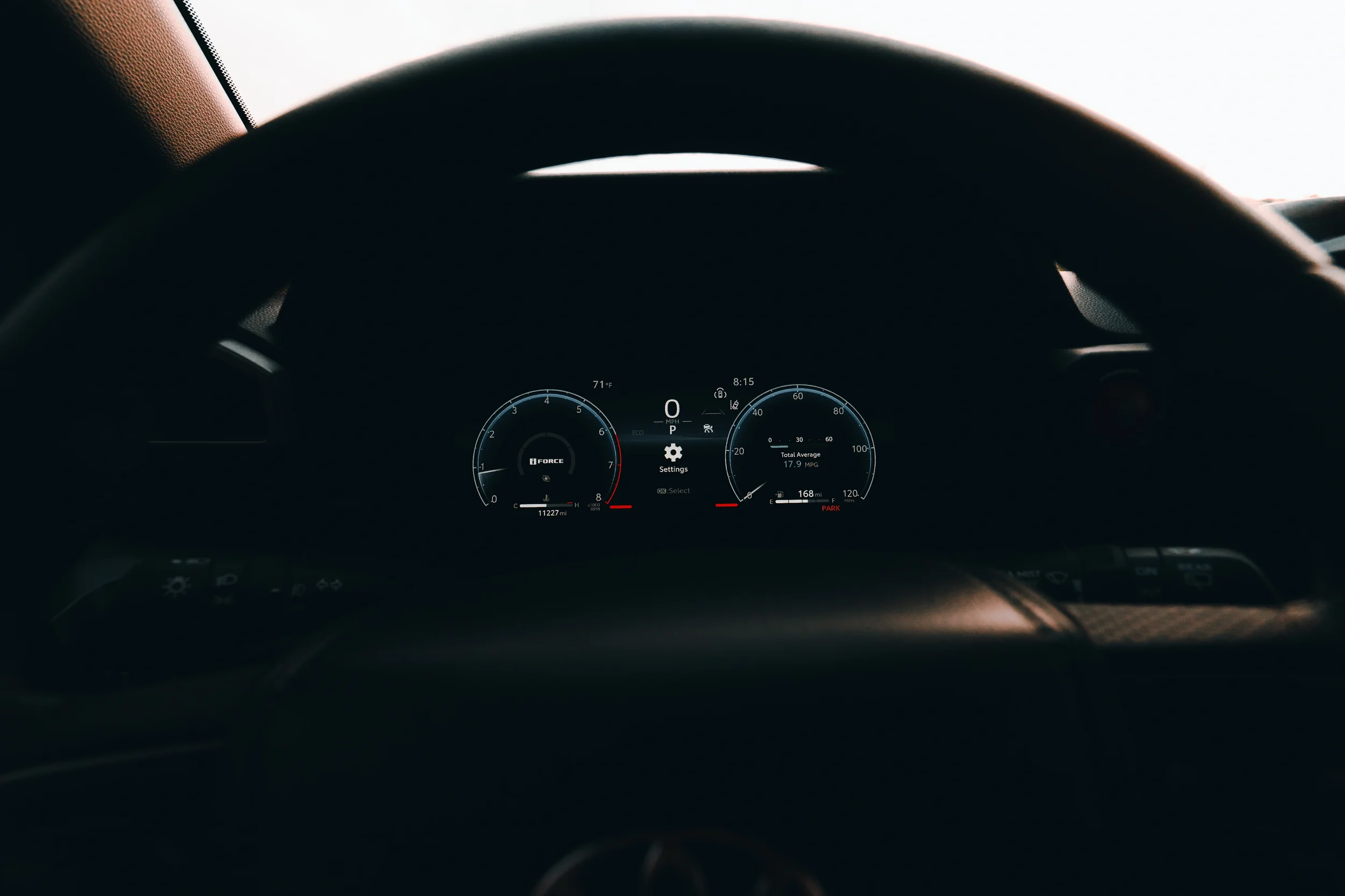 Interior view of a 2025 Toyota 4Runner TRD Sport with the steering wheel framing the digital gauge cluster in low light.