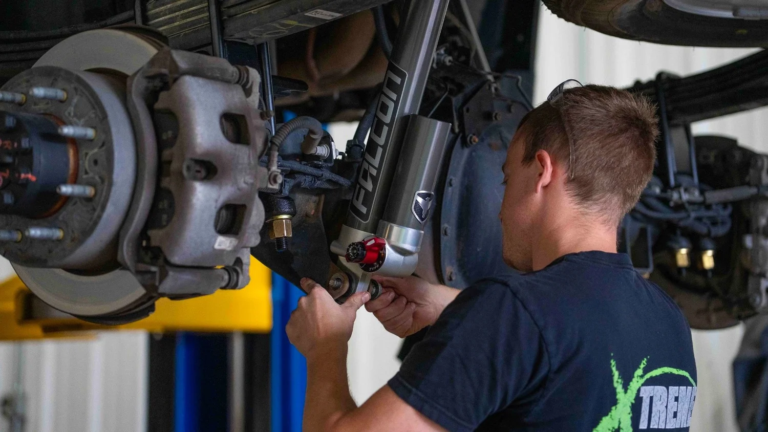 Pittsburgh commercial industrial photography by Ian Jones for ISJDESIGNS, showing a technician installing a Readylift suspension system on a truck at Xtreme Car and Truck in Bridgeville PA.