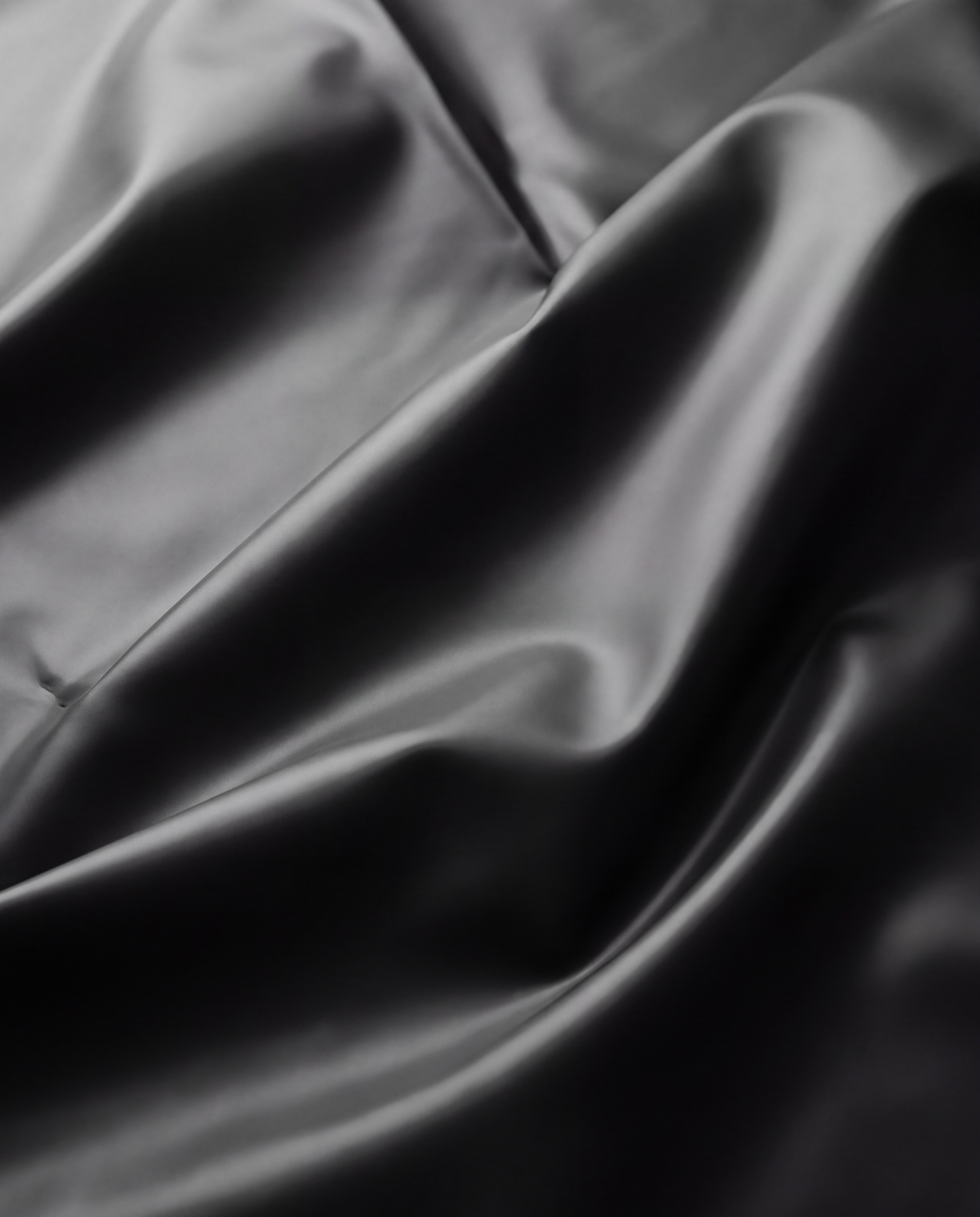 Close-up of folded black liner material showing its smooth texture and highlights, macro product photography by Ian Jones of ISJDESIGNS.