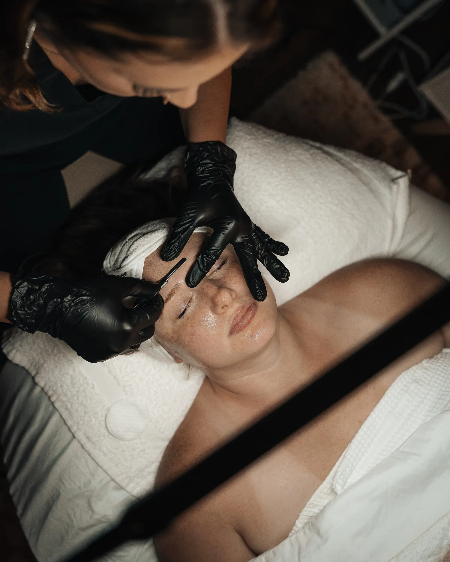 Esthetician performing a brow treatment, photographed for Pittsburgh med spa and aesthetic practice marketing