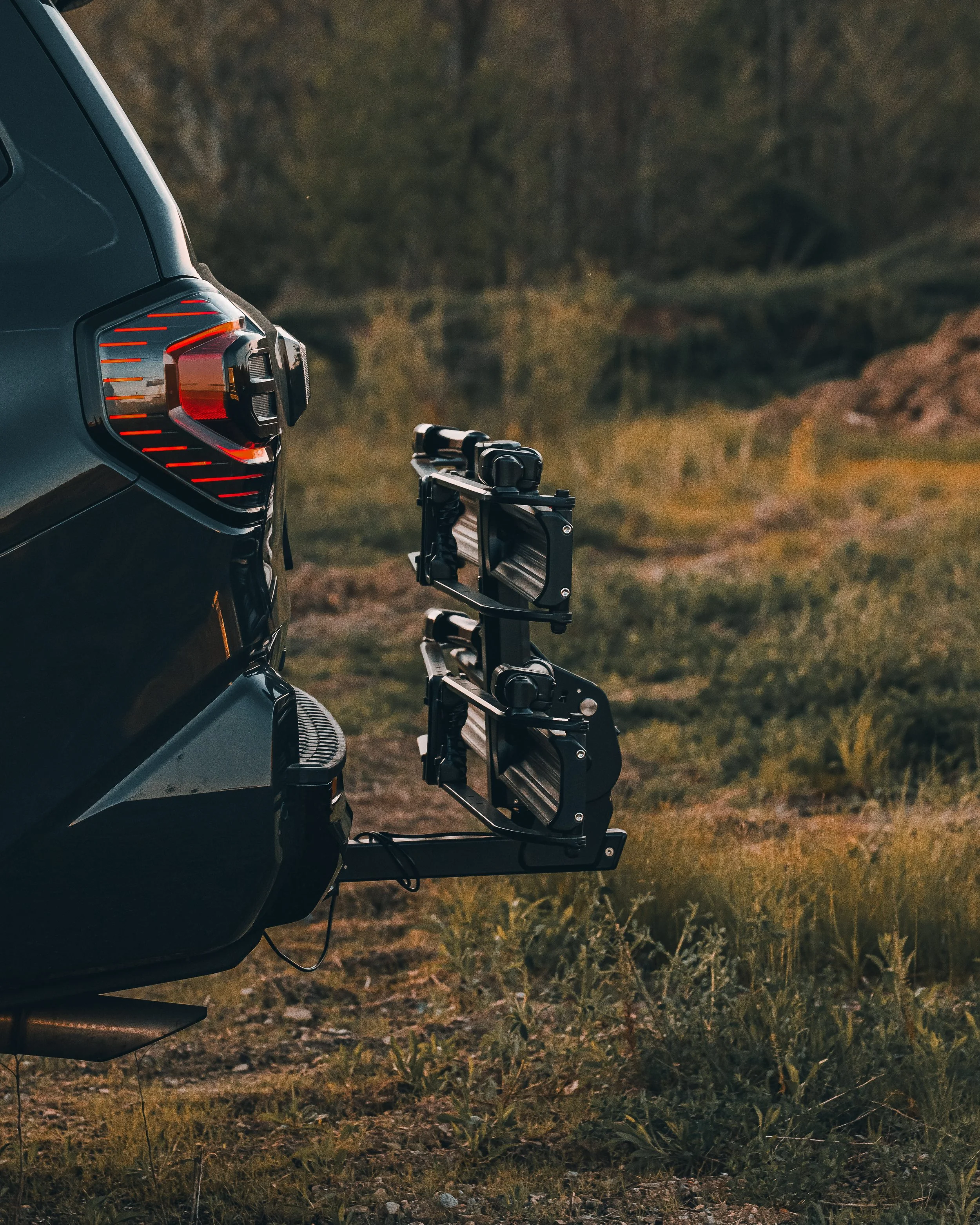 Mountain bike loaded onto the Kuat Piston Pro X bike rack on Ian Jones' 2025 Toyota 4Runner TRD Sport, showing the FastFit wheel chock system, no-frame-contact tire clamp, and 67-pound per-tray weight capacity that supports heavy ebikes and full-suspension mountain bikes.