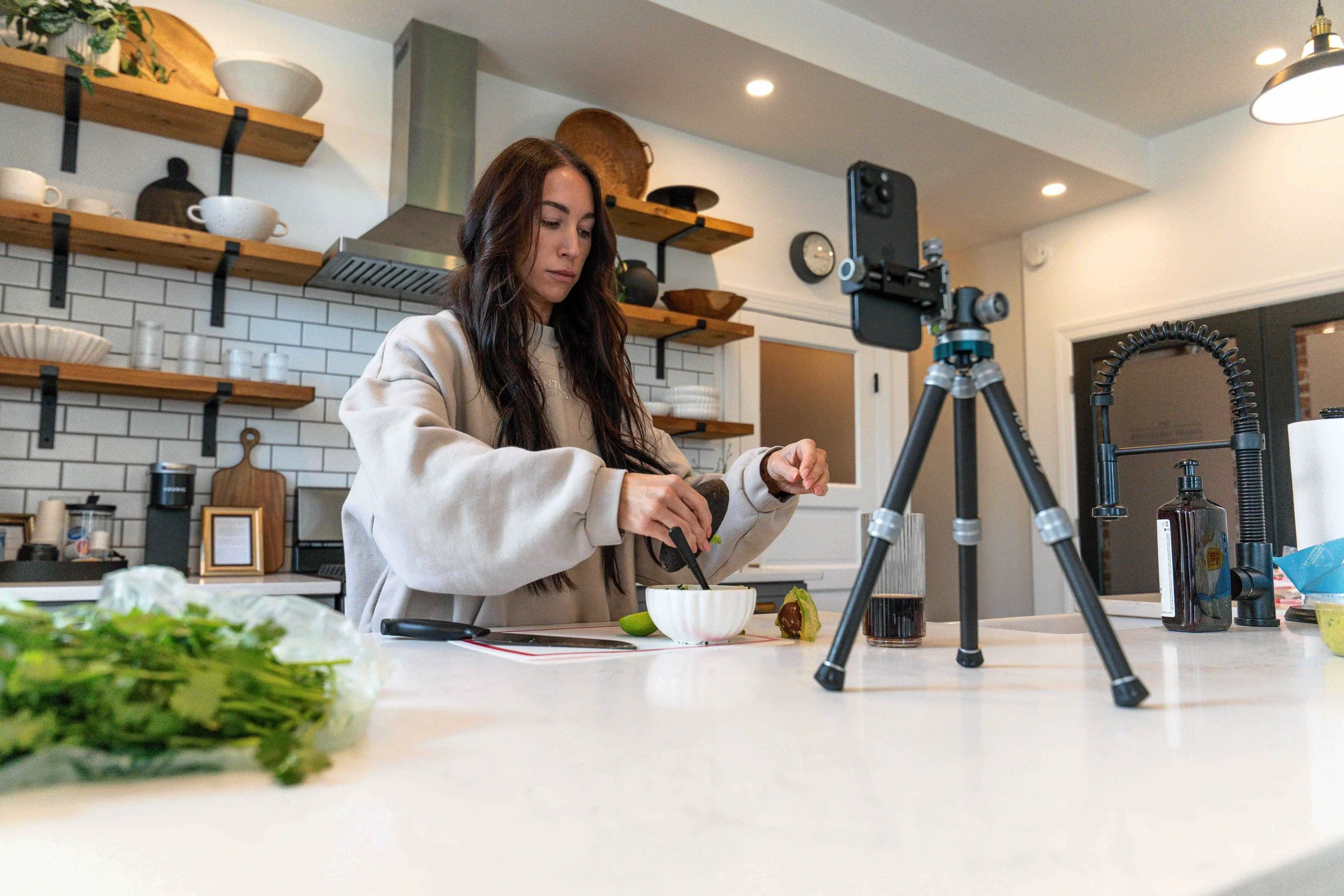 ProMaster iota 219 tripod set up on a kitchen island filming a creator making guacamole hands-free