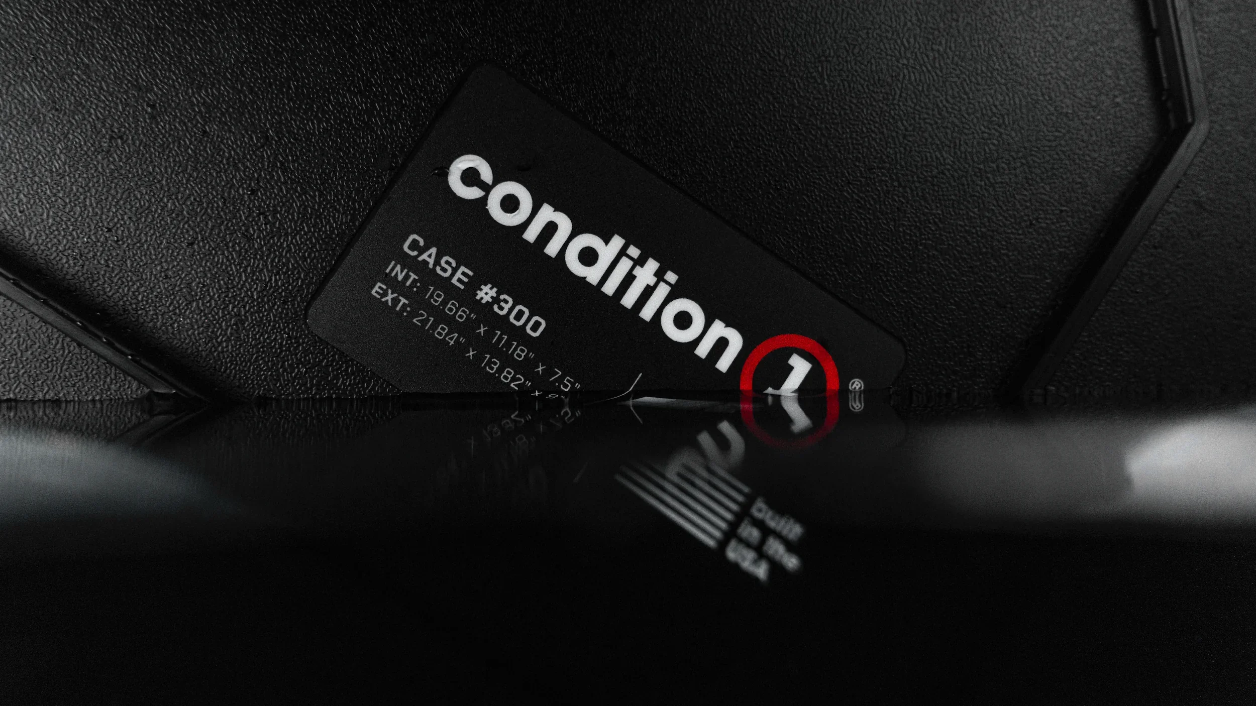 Condition 1 Case 300 rugged waterproof case shot on a dark reflective surface with water droplets