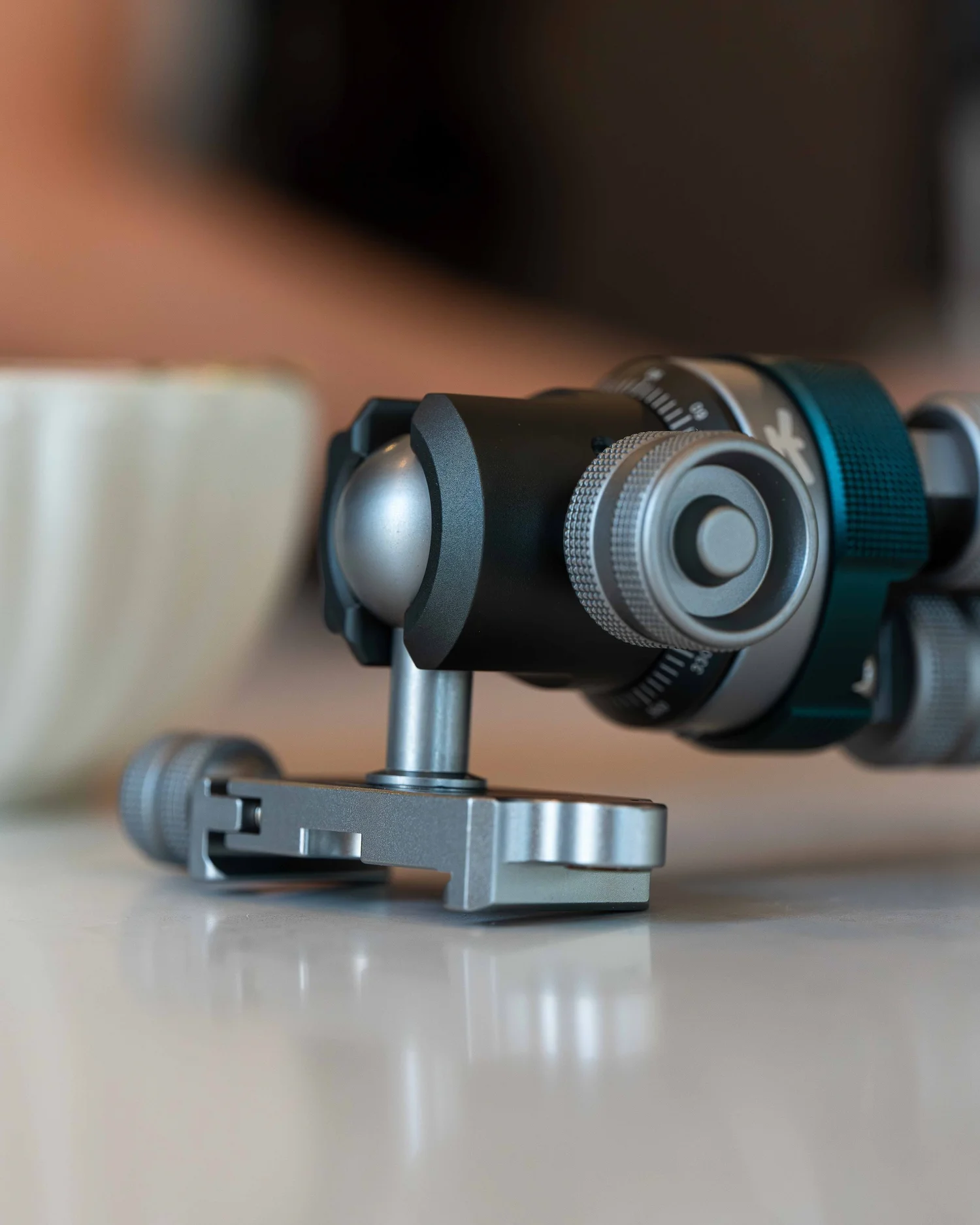 Macro detail of the ProMaster iota 219 single-knob ball head and Arca-compatible quick release plate