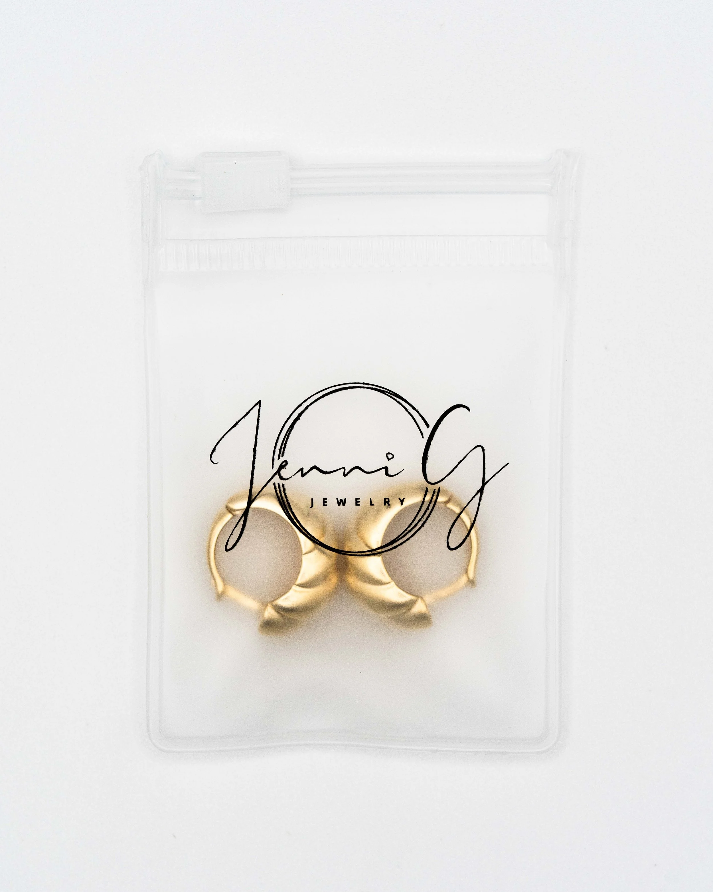 Brushed gold hoops in branded Jenni G Jewelry packaging, flat on white for a listing. Ian Jones, ISJDESIGNS.