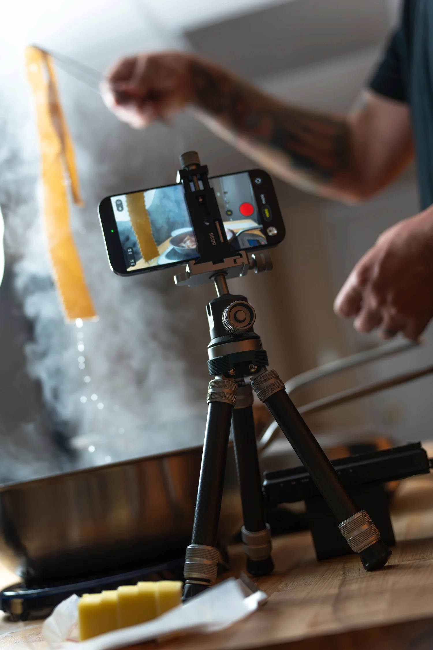 ProMaster iota 219 tripod holding an iPhone in video mode while fresh pasta is dropped into a steaming pan