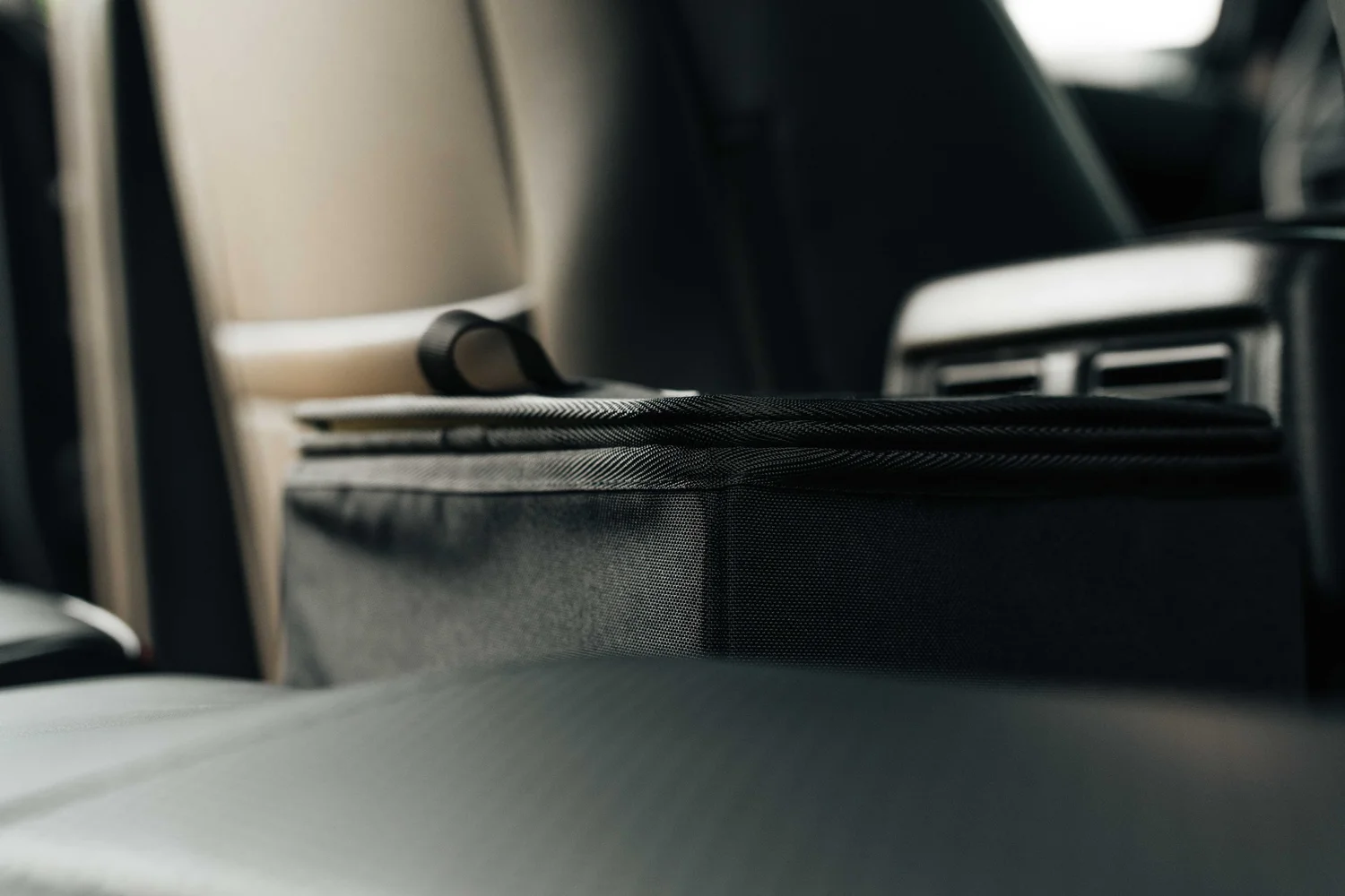 Close-up of the black Double Deez Goodz car trash can lid inside a vehicle with a softly blurred interior, photographed by Ian Jones of ISJDESIGNS.