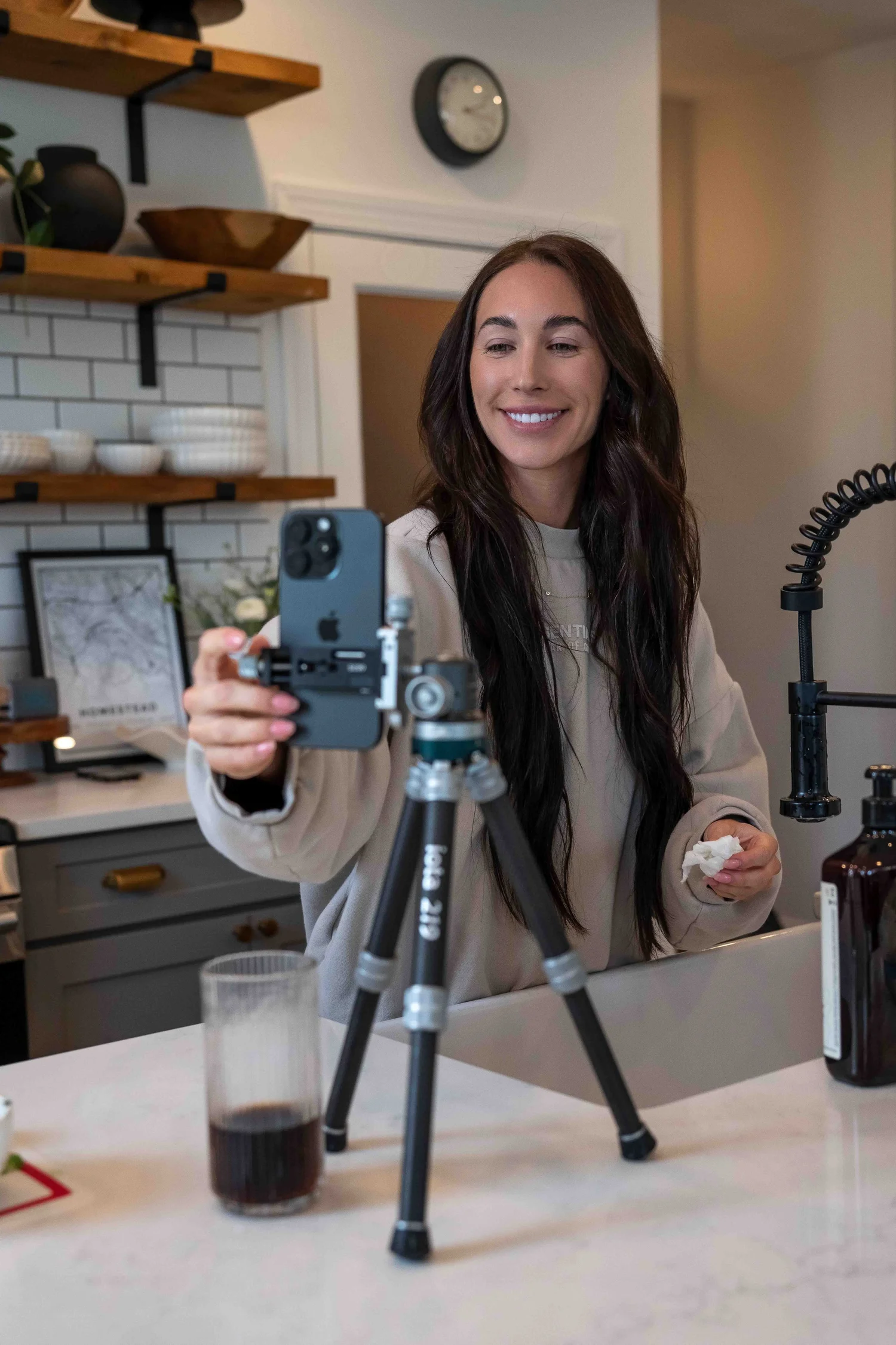 Creator reaching to start recording on a phone mounted to a ProMaster iota 219 tripod