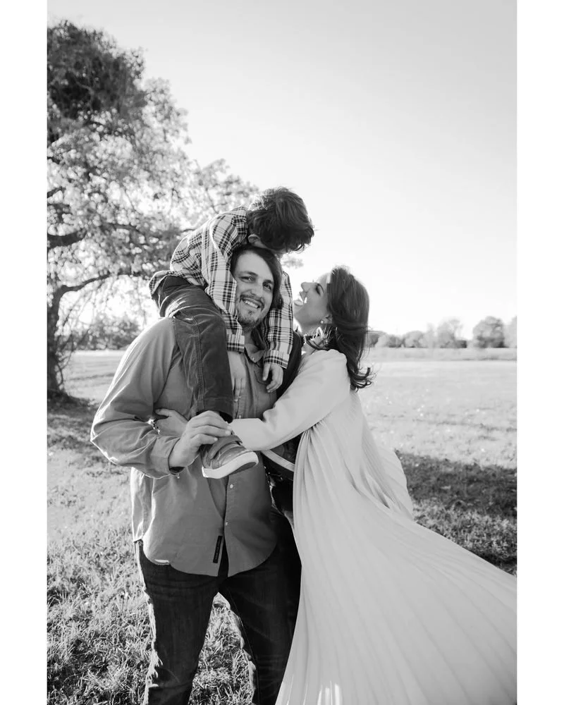 Jake Michael with his son Fred on his shoulders and his wife Leigh in a Round Top field