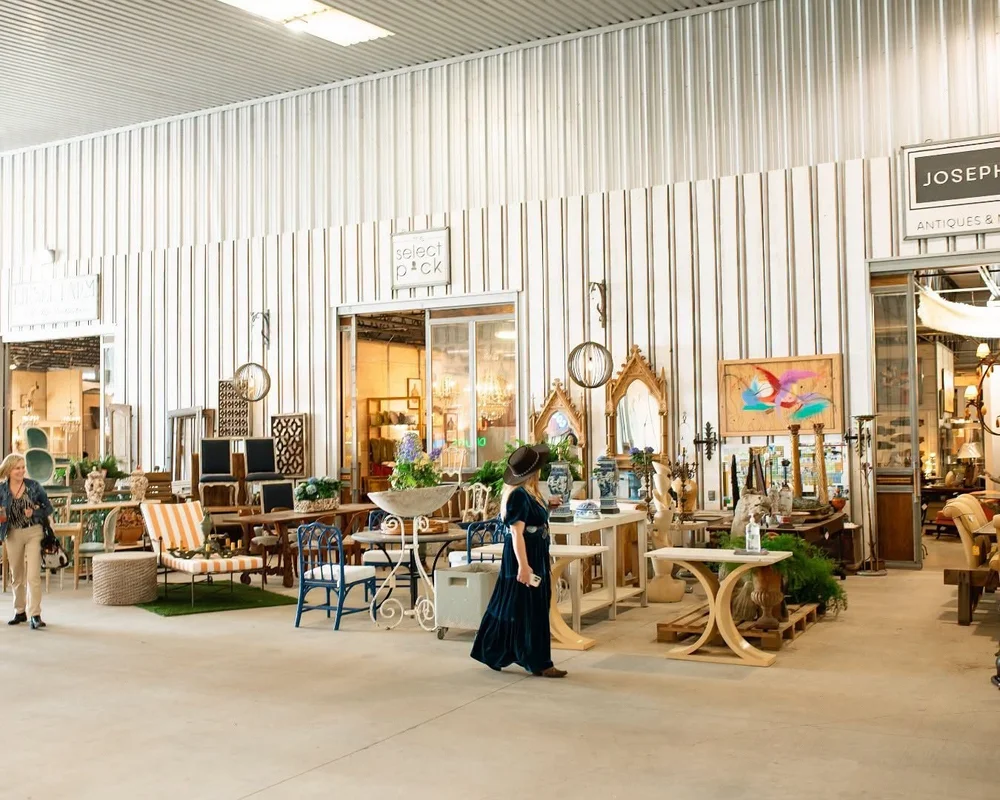 Shoppers walking past dealer storefronts inside a covered hall