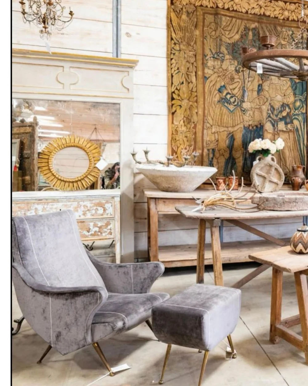 Velvet midcentury chair and ottoman before a sunburst mirror and antique tapestry