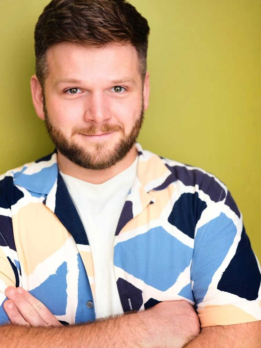 Dennis Connors headshot: arms folded, blue-and-apricot patterned shirt, chartreuse wall, half-smile.