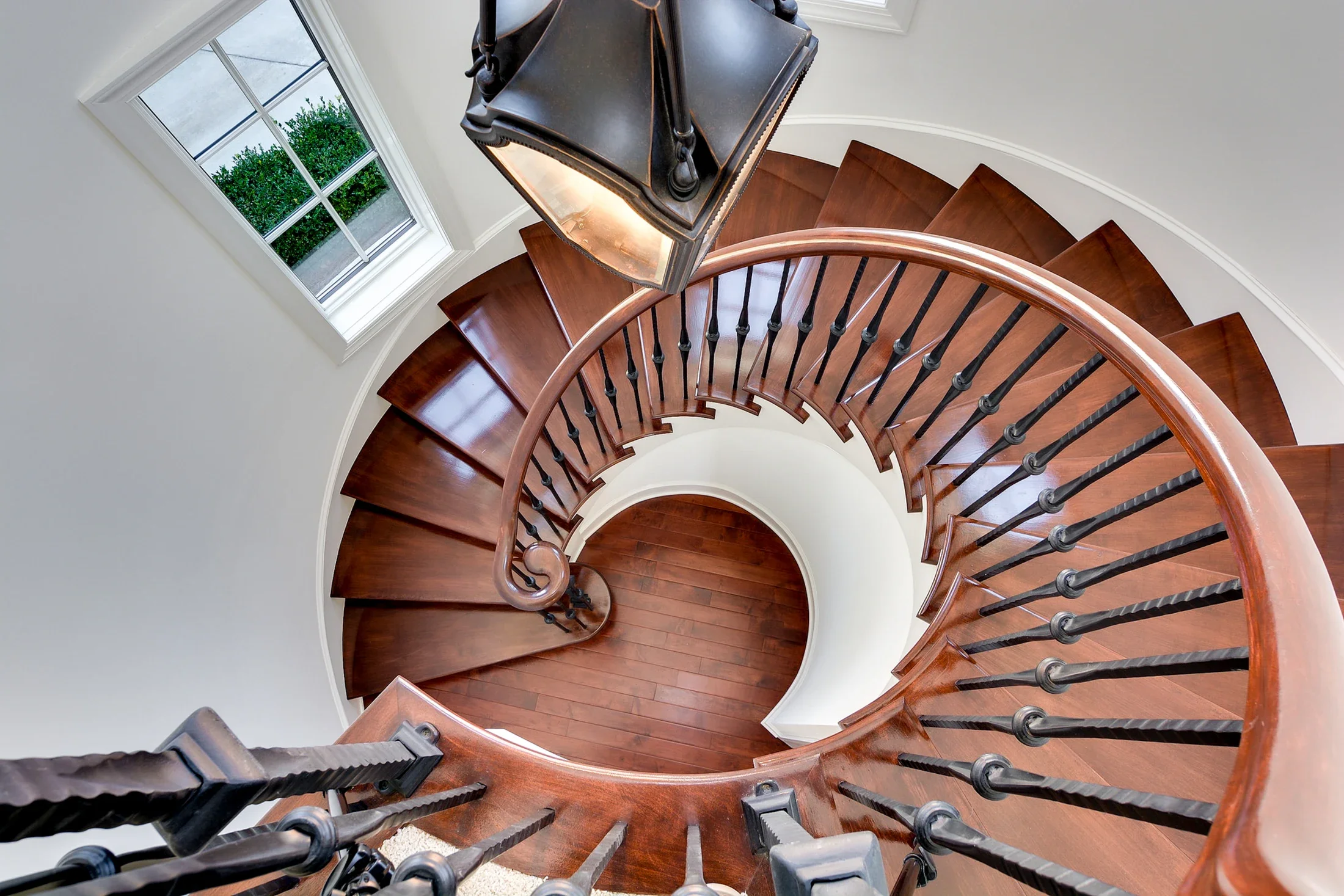 A sculptural wooden spiral staircase photographed from above