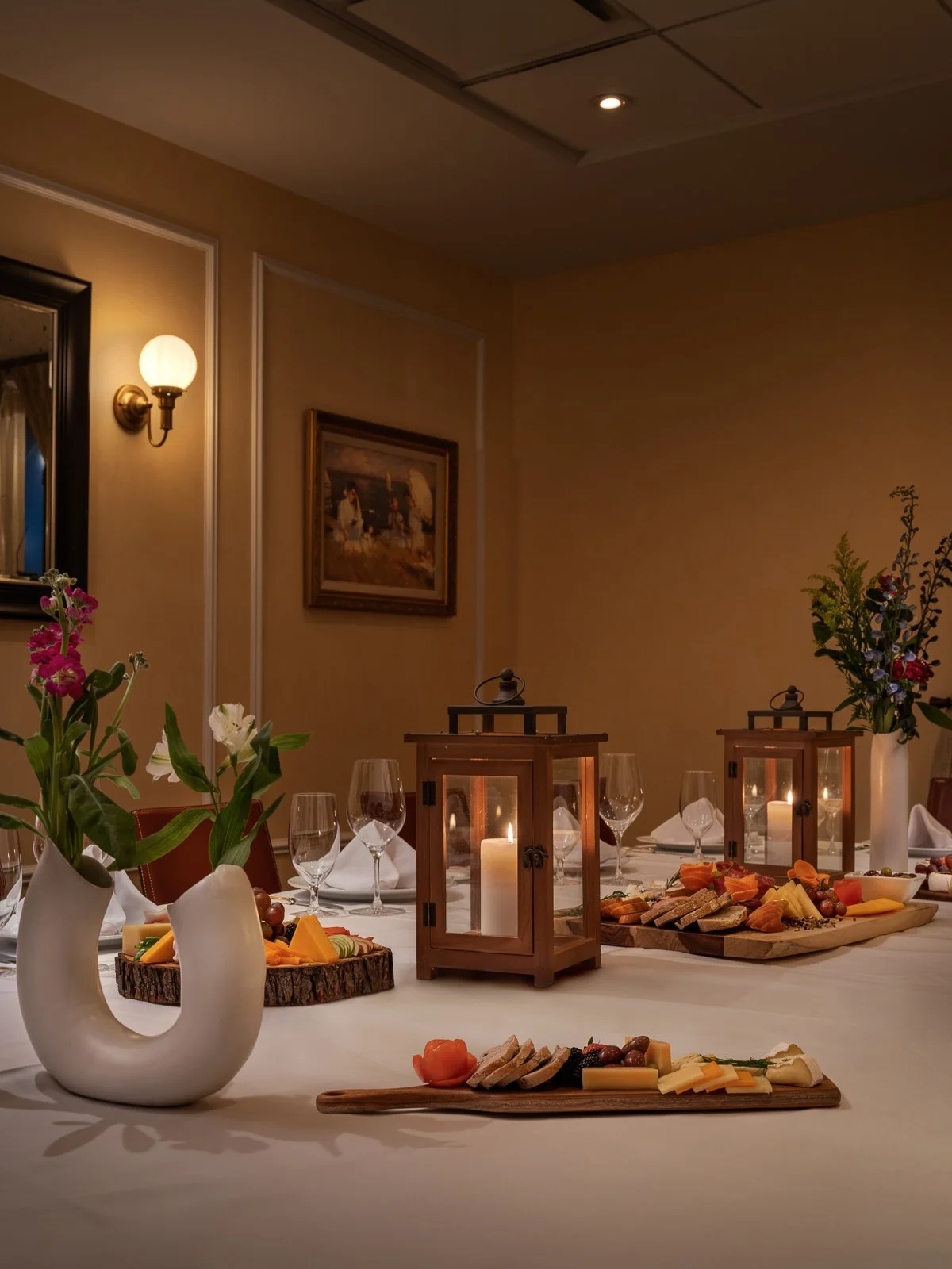 Candlelit gathering table with cheese boards and flowers