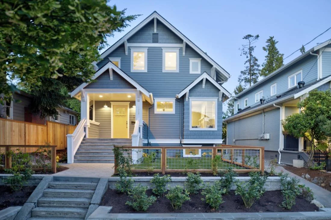 A blue craftsman home at dusk