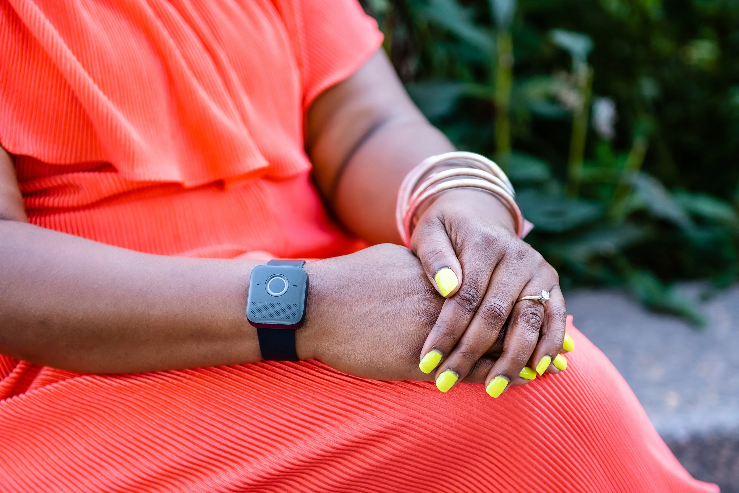 Older adult sitting outdoors wearing a medical alert wristband