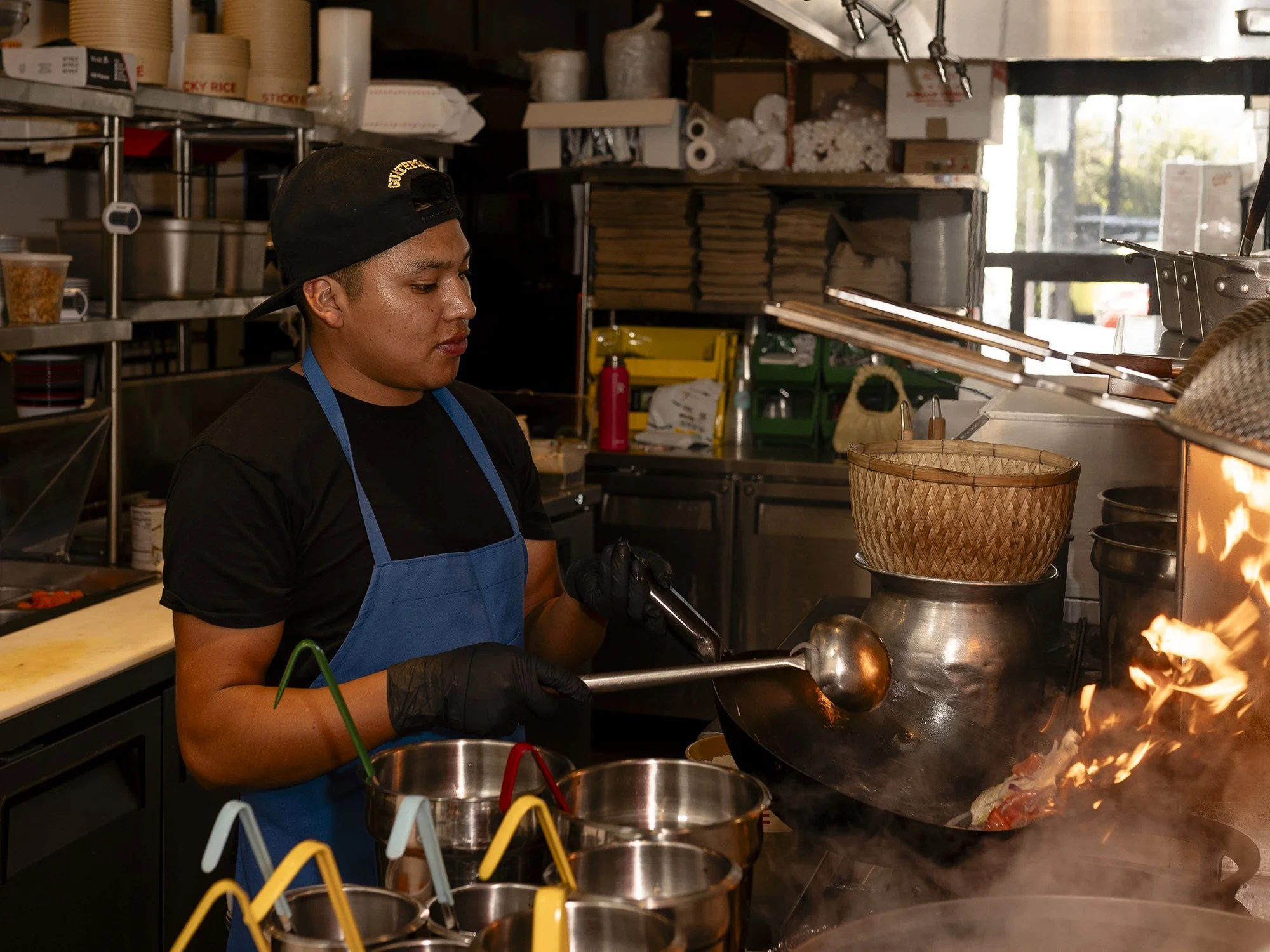 A cook firing the wok line at Sticky Rice on West 3rd Street