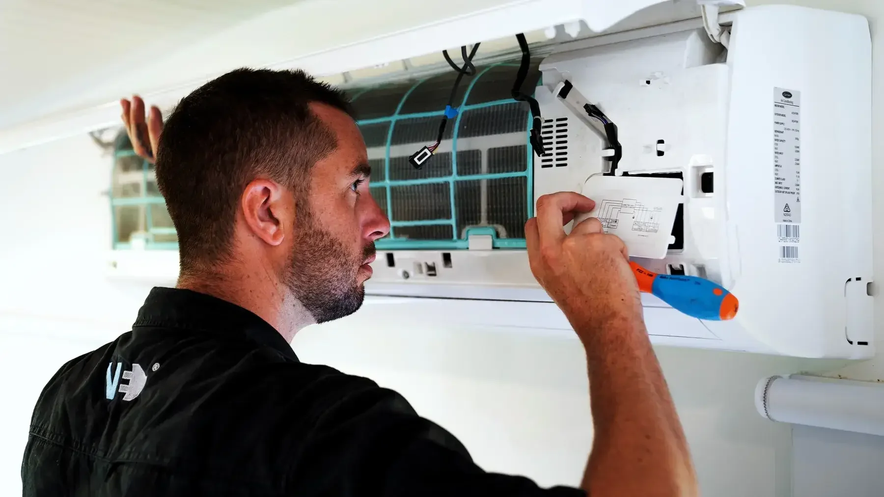 Vision Electrical technician installing a split system air conditioner